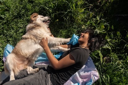 Govinda Martínez jugando en el césped con su mascota 'Sullivan'.