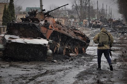 Un soldado ucranio observa un carro de combate ruso destrozado durante los primeros días de la invasión, el domingo en una calle de Bucha. Ucrania ha denunciado las “atrocidades” cometidas por los soldados rusos en Bucha, Irpin y Gostómel, localidades situadas a las afueras de Kiev, la capital del país, en las que los soldados ucranios han recuperado el control tras la retirada de las fuerzas de Moscú.