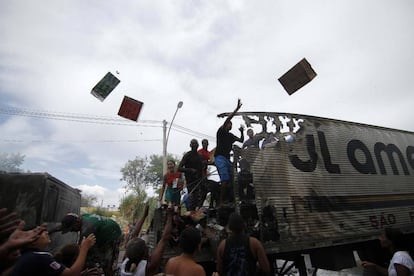 Grupo de pessoas saqueia caminhão no Rio.