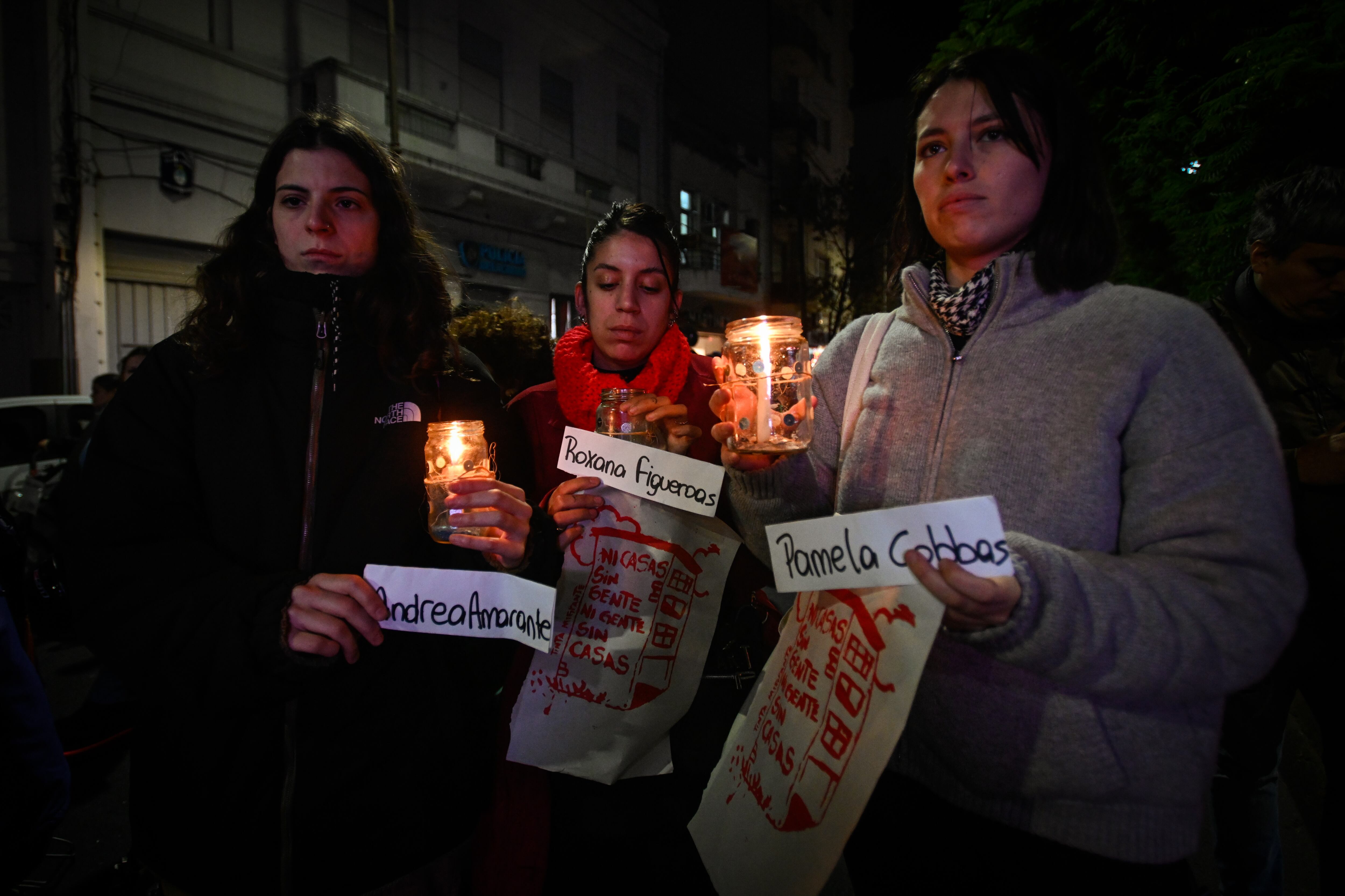 Tres mujeres sostienen los nombres de las víctimas de lesbicidio en la Plaza Colombia, en Buenos Aires, este 13 de mayo. 