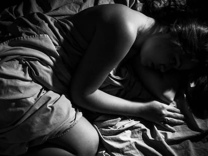 Una mujer yace en una cama.