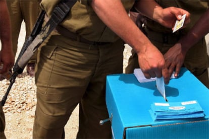 Un soldado israelí introduce su voto en una urna portátil junto a la frontera con Egipto y la Franja de Gaza.
