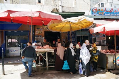 No mercado Mansheya, em Alexandria, um grupo de mulheres se reúne em frente a uma barraca de peixe, um dos itens mais caros dos últimos anos.