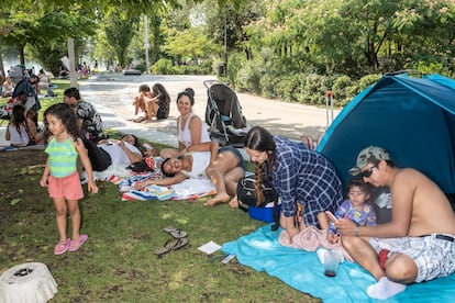 Cleber Calderón (a la derecha) junto a su hija y su mujer en el césped de los chorros de Madrid Río.
