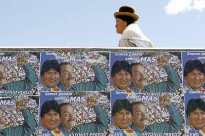 Una mujer camina junto a carteles de MAS, el partido de Evo Morales, en La Paz.