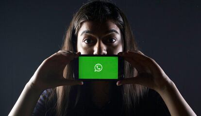 WhatsApp en un móvil delante de la cara de una chica