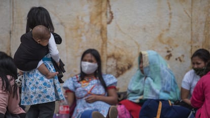 Una niña indígena embera carga a un bebé en la Plaza de Bolívar de Bogotá