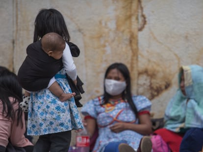 Una niña indígena embera carga a un bebé en la Plaza de Bolívar de Bogotá (Colombia), en abril de 2020.