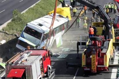 Una grúa endereza el autobús volcado en el accidente ocurrido en la carretera de Burgos.
