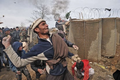 Jóvenes afganos tiran piedras a soldados estadounidenses a las puertas de la base de Bagram (a unos 60 kilómetros al norte de Kabul) en una protesta contra la profanación del Corán.