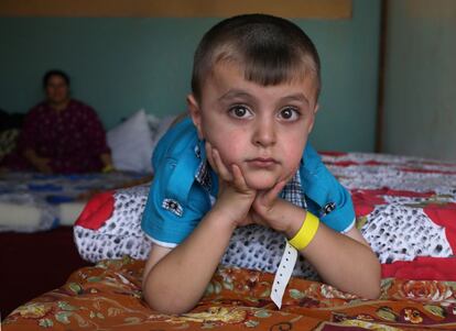 Un niño iraquí mira a cámara desde el colchón donde duerme. Se ha refugiado junto a su familia en la iglesia habilitada como refugio de emergencia de Ainkawa, un barrio de Irbil de mayoría cristiana.