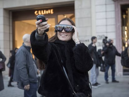 Una noia prova les ulleres de realitat virtual al passeig de Gràcia.