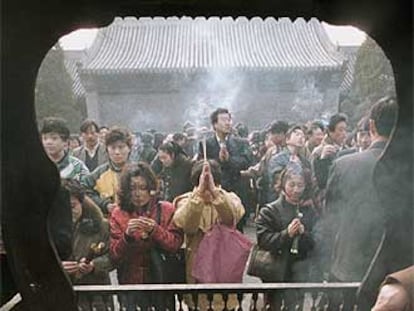 Un grupo de chinos ora y quema incienso en un templo de Pekín con motivo del nuevo año lunar.