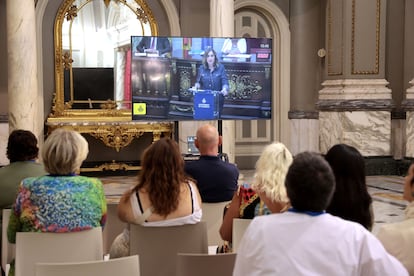 Público siguiendo el debate del estado de la ciudad del Ayuntamiento de Valencia desde una pantalla colocada en el Salón de Cristal, con la intervención de la alcaldesa María José Catalá. 
