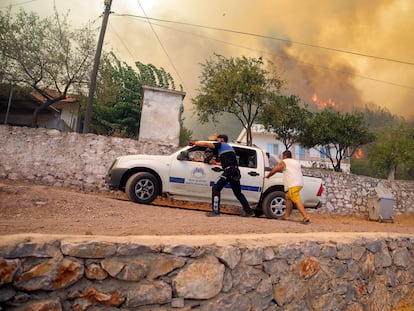 Varias personas escapan del avance de las llamas en el pueblo de Cokertme en la provincia turca de Mugla este lunes