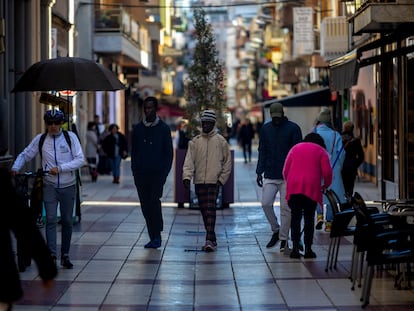 Varias personas de origen subsahariano pasean por la calle de la iglesia de Calella.