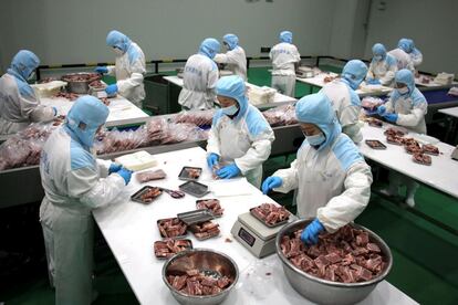 Varios trabajadores empaquetando carne congelada para su exportación en una planta de procesamiento de carne de ternera en Binzhou, en la provincia de Shandong, al este de China. 