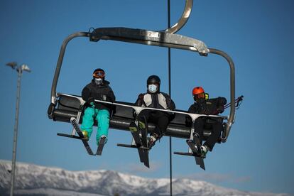 Tres esquiadores con mascarilla, en un telesilla de la Masella. 