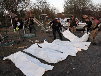 La policía cubre los cuerpos de varias víctimas del ataque atribuido a Rusia en Hroza, en el este de Ucrania, este jueves.