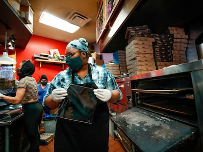 Empleadas de la pizzeria Dimo's fabrican mascarillas de acrílico en Chicago.