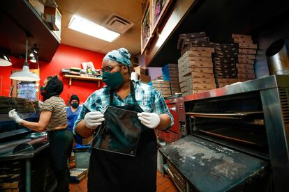 Empleadas de la pizzeria Dimo's fabrican mascarillas de acrílico en Chicago.