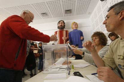 Un hombre introduce su voto en una de las urnas en el Casal de barrio Sant Pere de Terrassa.