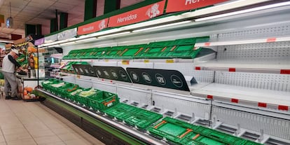 Estantes de un supermercado en Madrid, vacíos de mercancía este martes debido a la elevada afluencia de clientes registrada durante la jornada.