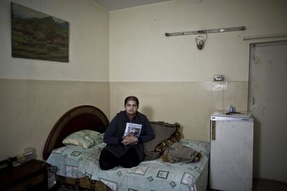 El médico Mohamed Amir, de 31 años, muestra la foto de su padre Malik Sanaullah, de 63 años, "Echo de menos sus consejos, voy a levantar la cabeza e intentaré que se sienta orgulloso de mi", asegura Mohamed sentado en la cama de su padre.