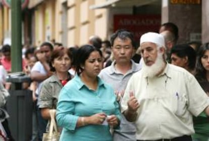 Numerosos inmigrantes de varias nacionalidades hacen cola para cumplimentar diversos trámites en la sede del Ministerio de Trabajo y Asuntos Sociales en Madrid. EFE/Archivo