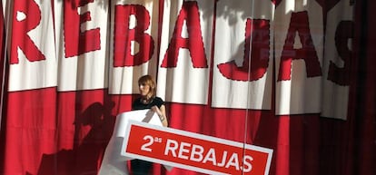 Una dependienta coloca un cartel de rebajas en enero de este a&ntilde;o.