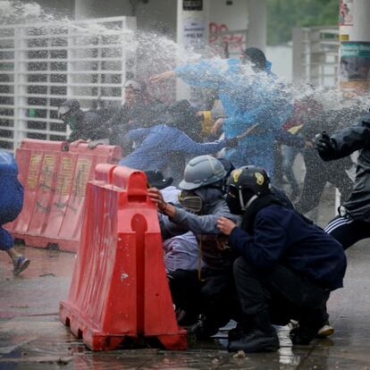 A demonstrator throws a rock as others take cover during a protest in commemoration of the victims of the 2021 national strike, in Bogota, Colombia April 28, 2022. REUTERS/Luisa Gonzalez