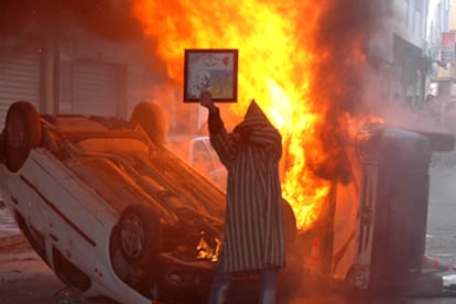 Coches incendiados en el centro de Alhucemas, en la tarde del domingo.