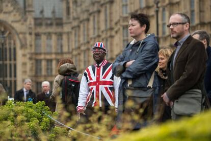 Un hombre vestico con la bandera británica frente al Parlamento, en Londres.