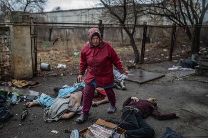 En esta otra imagen de la serie de Palacios, 
Olga, de 80 años, camina entre los cuerpos sin vida de hombres asesinados junto al edificio que sirvió como cuartel general de las tropas rusas en Bucha. Era 2 de abril de 2022, y lo últimos soldados de Moscú acaban de dejar la ciudad. Olga vivió el mes bajo la ocupación rusa con su esposo Mikokla, de 85 años, encerrados en casa.