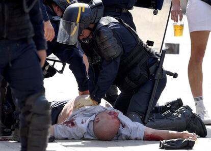 Un policía intenta reanimar con un masaje cardiaco a un hincha inglés herido en los enfrentamientos.