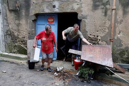 Residentes limpian sus viviendas tras las inundaciones en Villegailhenc (Francia).