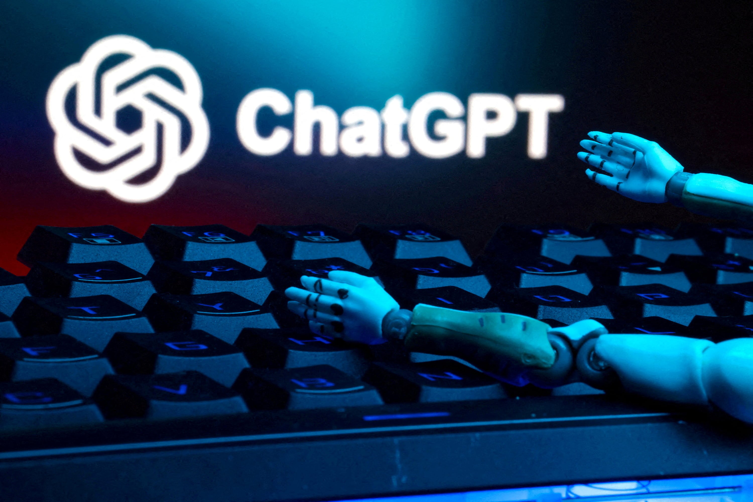 Imagotipo de ChatGPT, junto a un teclado y unas manos robóticas.