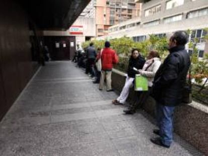 Varias personas esperan en la cola a la entrada de una Oficina de Empleo de Madrid. EFE/Archivo