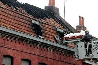 Los bomberos evacuan el cadáver de un fallecido del edificio incendiado ayer en Roubaix.