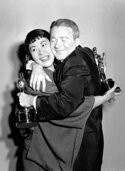 Miyoshi Umeki y Red Buttons se abrazan al conseguir su Oscar en 1958.