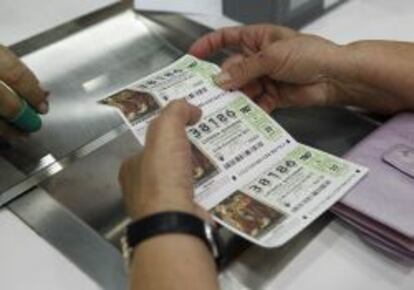 Venta de décimos para el sorteo extraordinario de lotería de Navidad en una administración.