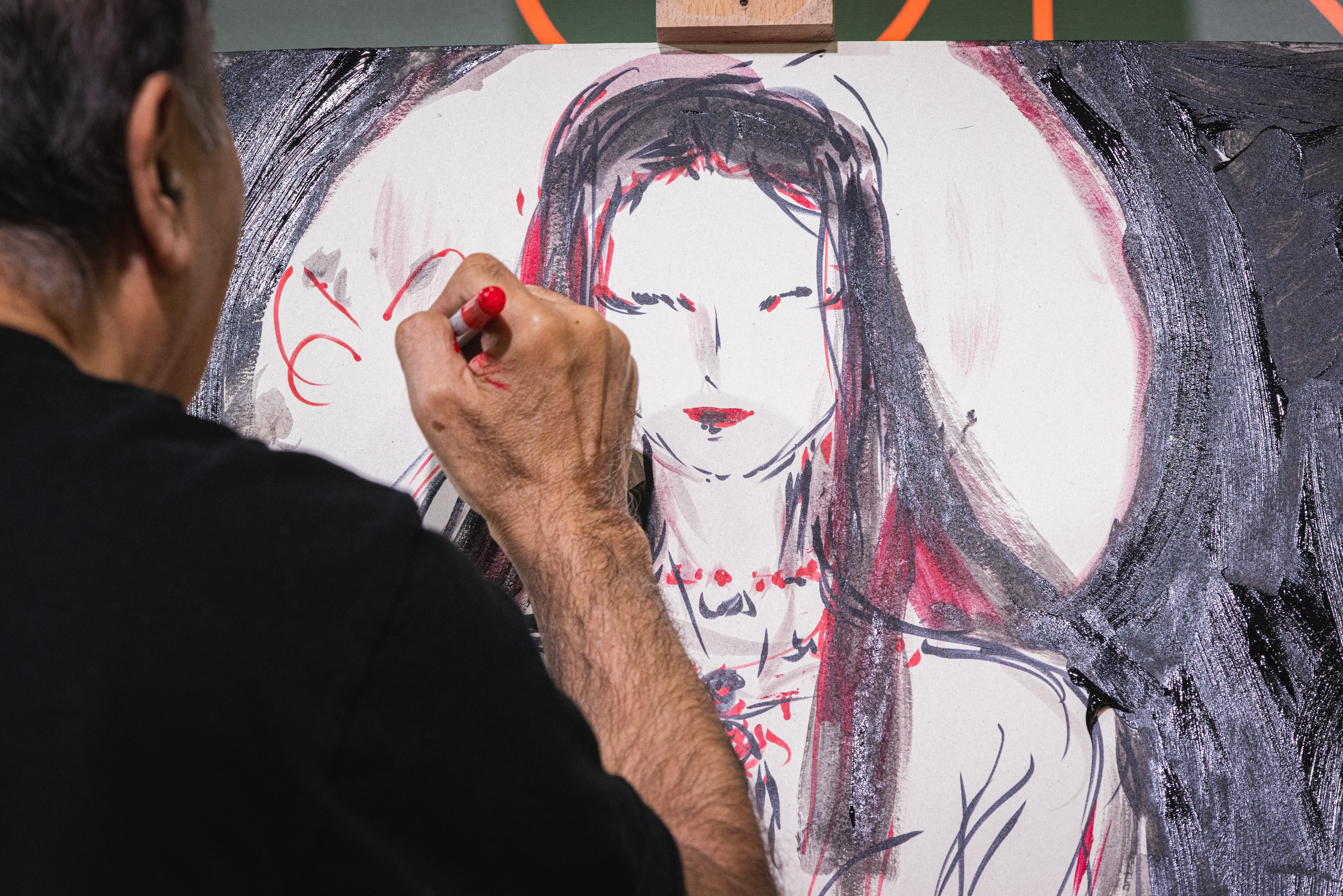 El artista japonés Yoshitaka Amano pintando frente al publico del festival Lucca Comics & Games esta semana. / Riccardo Bonuccelli