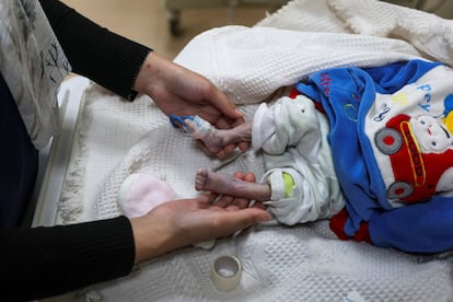 Una enfermera sostiene las piernas de un beb palestino que muri de hipotermia tras vivir en una tienda de campa?a con su familia desplazada, segn los mdicos, en el Hospital de los Mrtires de Al-Aqsa en Deir al Balah, en el centro de la franja de Gaza, el 29 de diciembre de 2024.