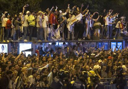 Aficionados madridistas en la plaza de Cibeles para ver a los jugadores del Real Madrid. 