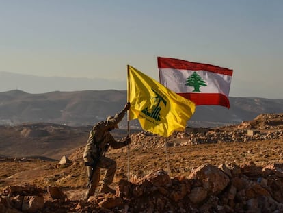 Un miliciano de Hezbol&aacute; planta las banderas libanesa y de la milicia tras expulsar a Al Nusra de los arreales de la localidad libanesa de Arsal