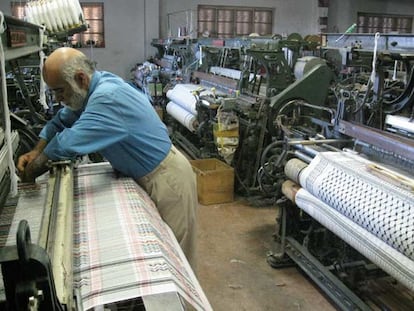 Abdelaziz el Karaki manipula uno de los telares de la nave de Hebrón donde trabaja desde hace 41 años.