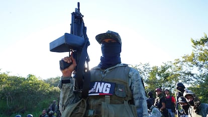 Un integrante de un brazo armado del CJNG, sostiene un arma de uso exclusivo del ejército mexicano, en Michoacán, en noviembre de 2023.