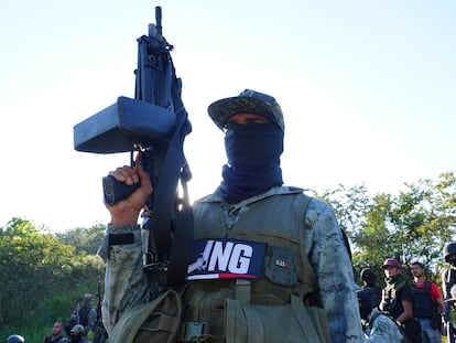 Un integrante de un brazo armado del CJNG, sostiene un arma de uso exclusivo del ejército mexicano, en Michoacán, en noviembre de 2023.