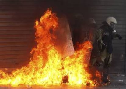 Policías antidisturbios se ven envueltos por las llamas de una bomba incendiaria durante los choques violentos de hoy, en Atenas, entre manifestantes y las fuerzas de seguridad ocurridos durante una manifestación con motivo de la huelga general de 24 horas que vive Grecia.