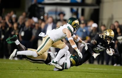 Colorado cornerback Travis Hunter (12) is dragged down after a short gain by Colorado State defensive back Henry Blackburn